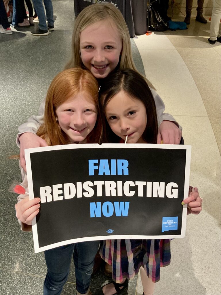 girls holding sign "Fair Redistricting Now."